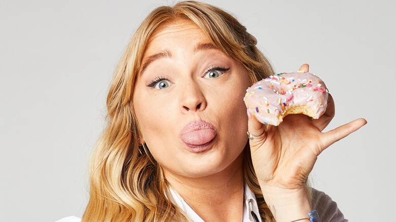 Alix Traeger holding doughnut and making a silly face