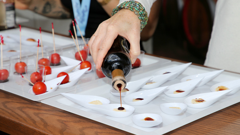 Woman pouring balsamic vinegar for tasting