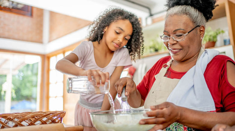 Child and grandmother cooking together