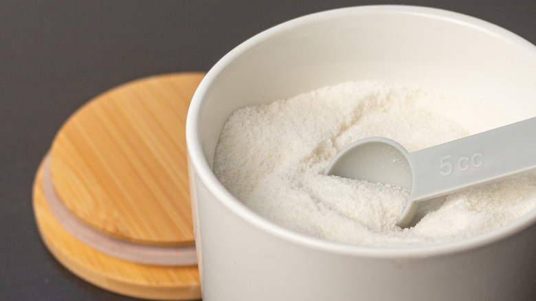Pot of sugar with a measuring spoon