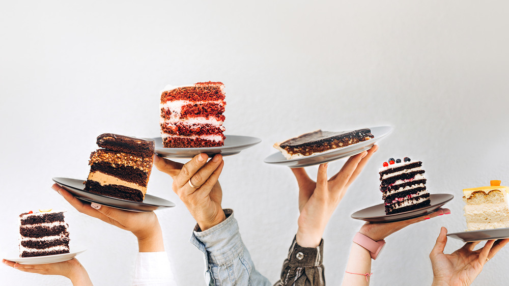 Hands holding different cake slices