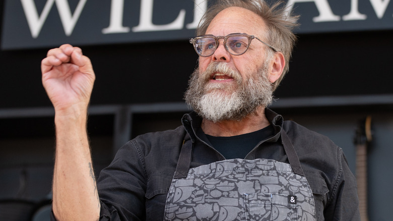 alton brown speaking with hand raised