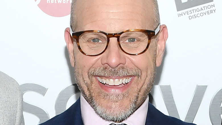 Close up of Alton Brown wearing glasses and smiling