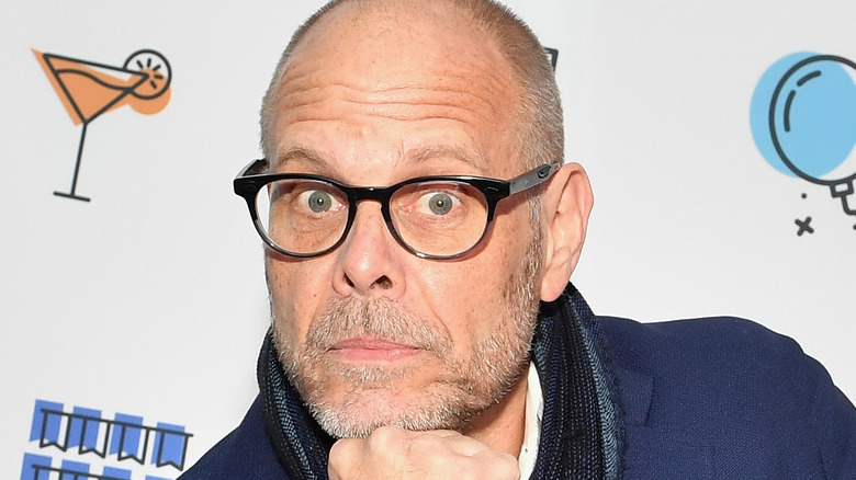 Alton Brown in glasses with hand under chin