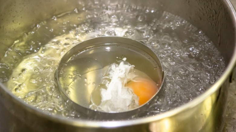 Egg being poached in a pan