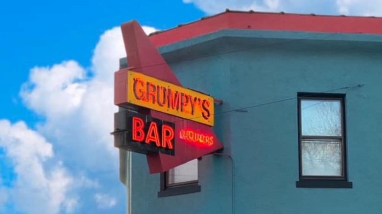the outside of a bar, with a sign that reads "grumpy's bar"