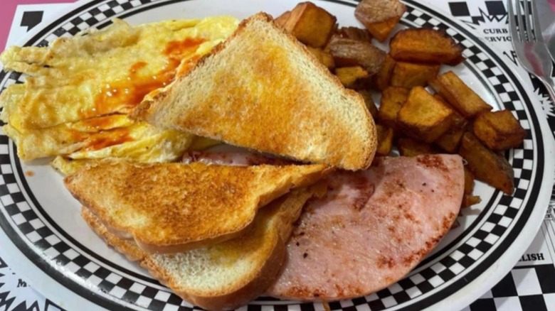 Eggs, toast, home fries, and ham on a plate