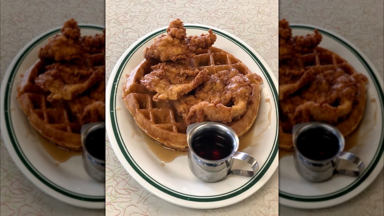 A plate of chicken and waffles with maple syrup at The Silver Skillet