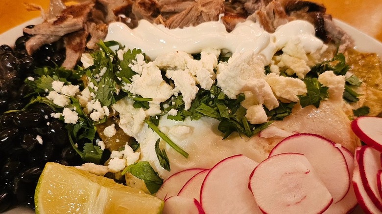 Chilaquiles Verdes with eggs, black beans, and carnitas at Al's Breakfast