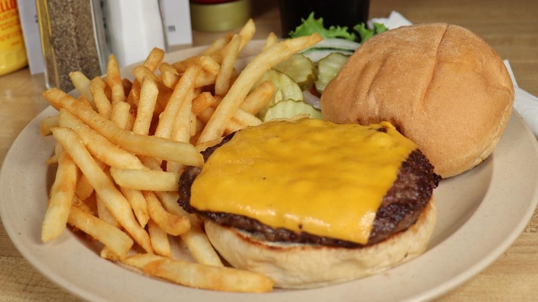 A cheeseburger and fries served on a plate at the Hi-Way Diner