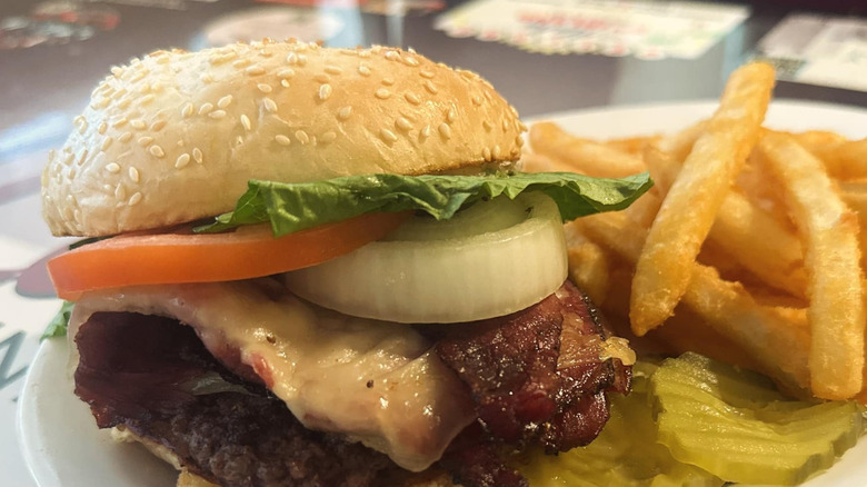 A pastrami burger with fries and pickles at Lou's Diner