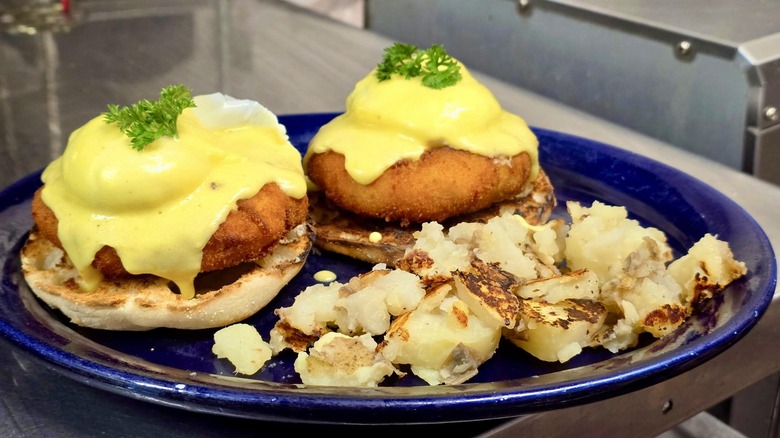 A plate from The Sunrise Shack featuring eggs Benedict over cheddar, bacon and chive croquettes