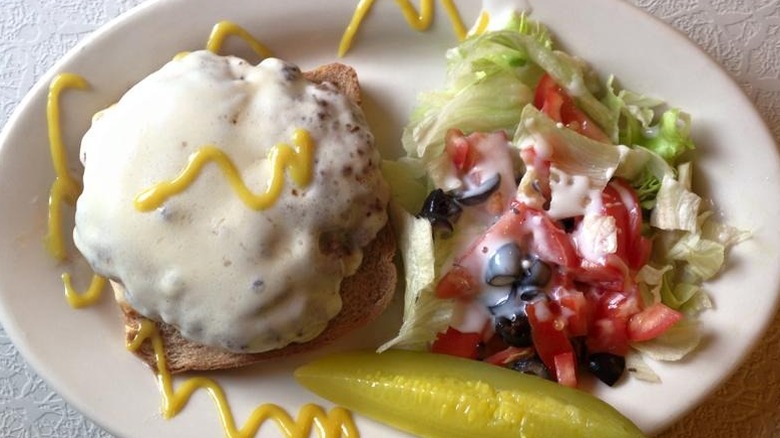An open-faced mushroom cheeseburger with side salad at Dumont Crystal Diner