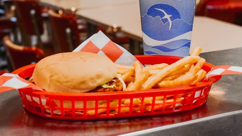A fried chicken sandwich and French fries in a basket at The Spot