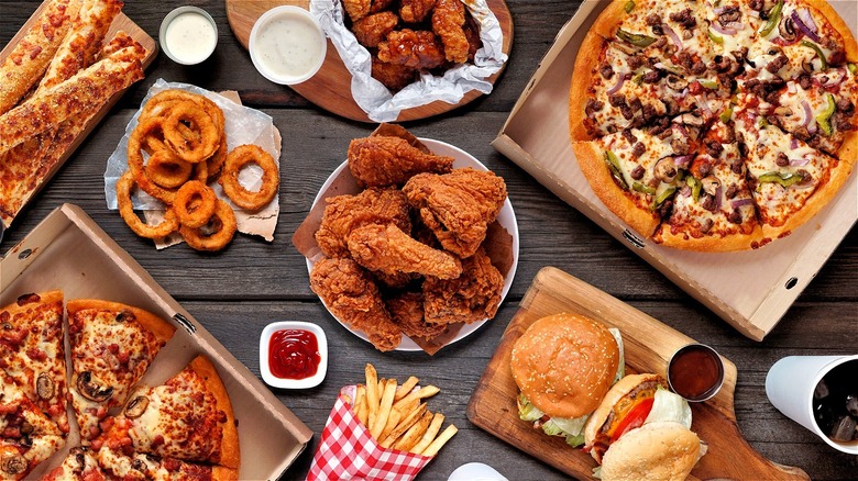 array of fast food pizza wings burger fries onion rings