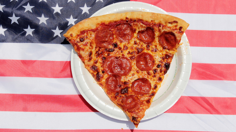 Slice of pepperoni pizza with American flag background