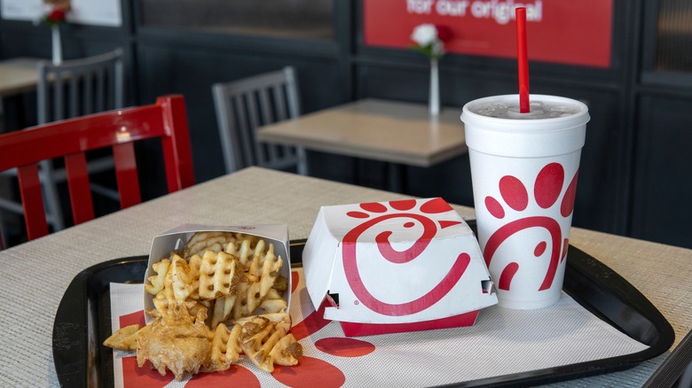 Front shot of food from Chick-fil-A. Fries, a sandwich box, and a drink on a tray