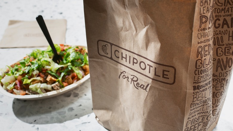 Chipotle bag in the foreground, Chipotle bowl in the background