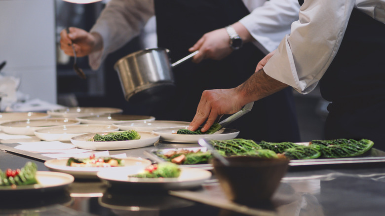 Chefs plating a vegetarian cabbage dish