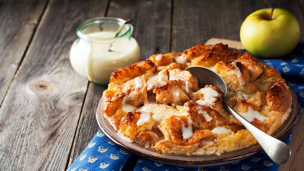 Bread pudding with sauce in a pitcher