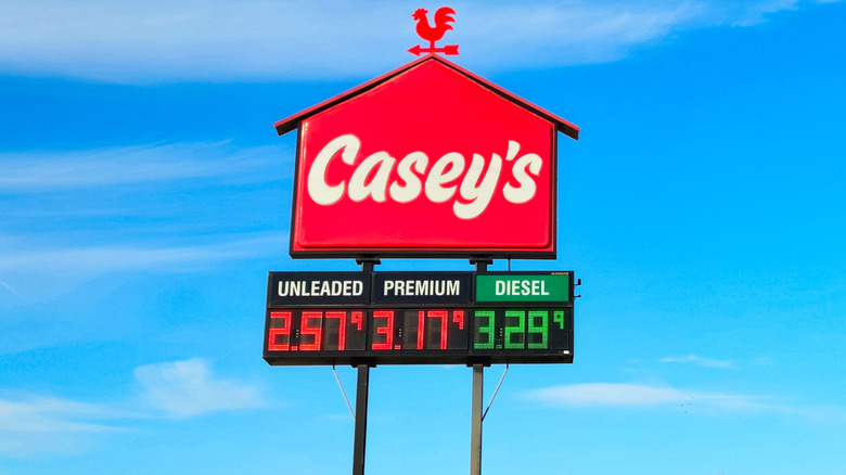 A Casey's sign against the blue sky as viewed from the highway.