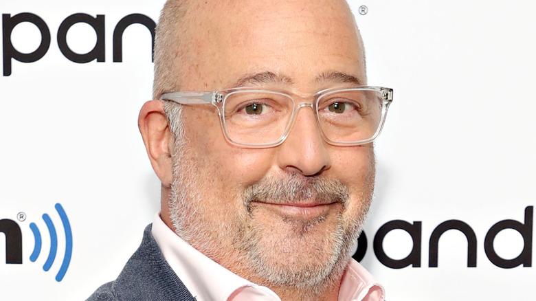 Andrew Zimmern smiles in glasses