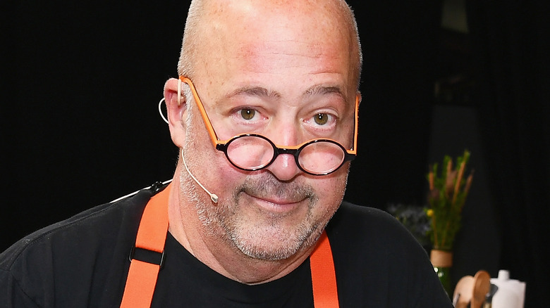 Andrew Zimmern smiles with glasses in head shot