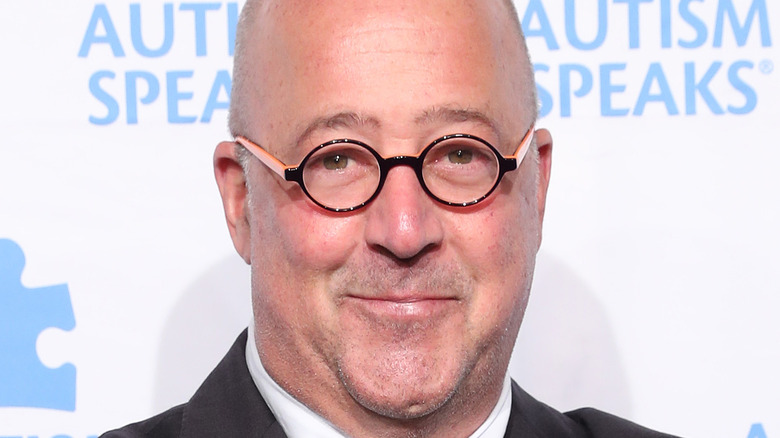 Andrew Zimmern in round glasses