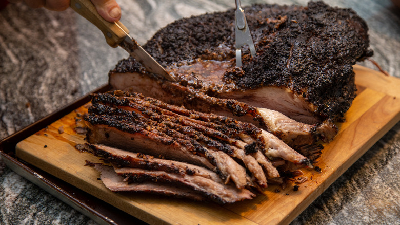 Slicing brisket on a chopping board