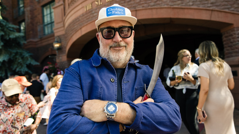 Andrew Zimmern holding a blade at a festival