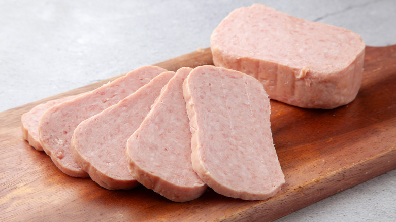 Slices of Spam canned meat on cutting board.