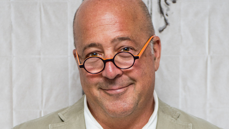 Andrew Zimmern smiling for cameras at a publicity event.