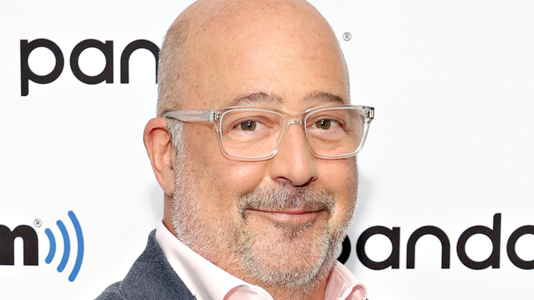 Andrew Zimmern in glasses and pink shirt