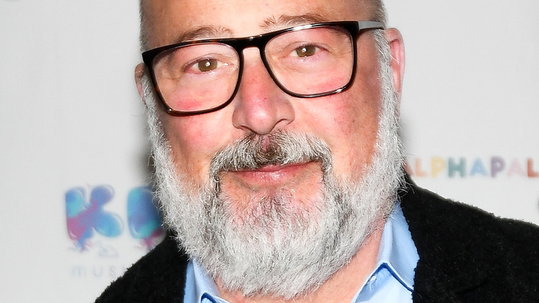 Andrew Zimmern wearing glasses with slight smile