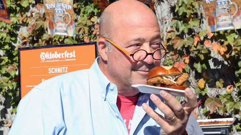 Andrew Zimmern sniffing a plate of food
