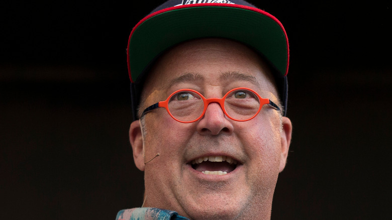 Andrew Zimmern with his head turned in a baseball hat