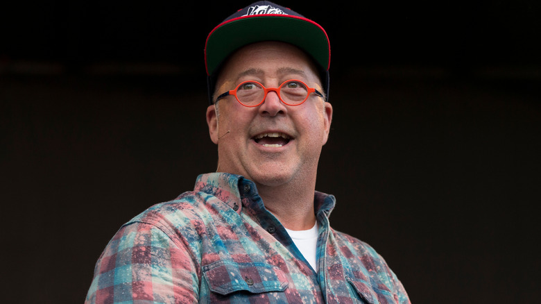 Andrew Zimmern with his head turned in a baseball hat