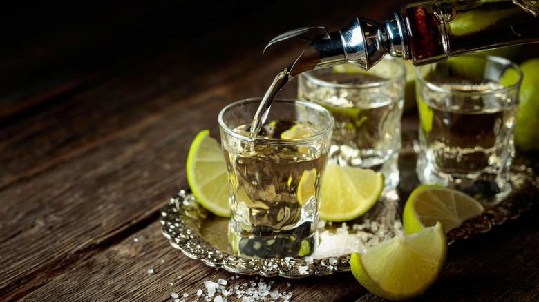 Shots of tequila with lime wedges