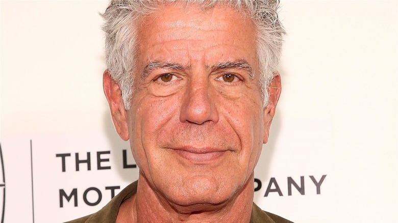 Anthony Bourdain smiles in green shirt