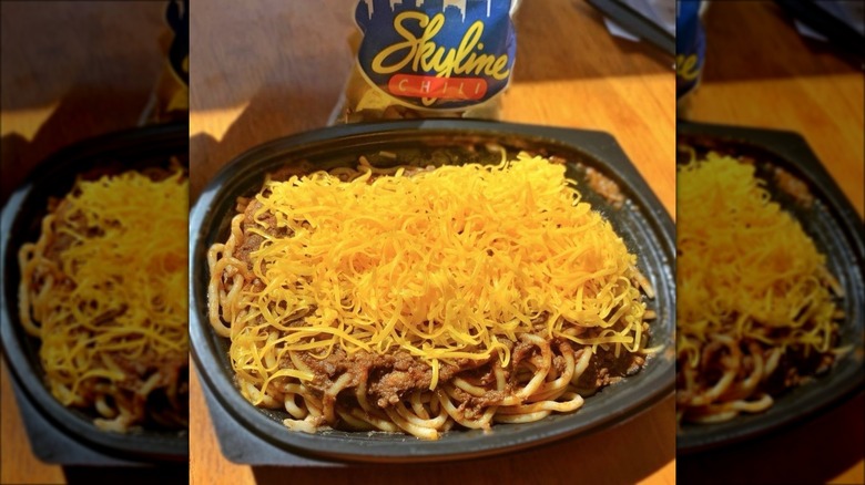 Takeout container of Skyline Chili with bag of oyster crackers in the background