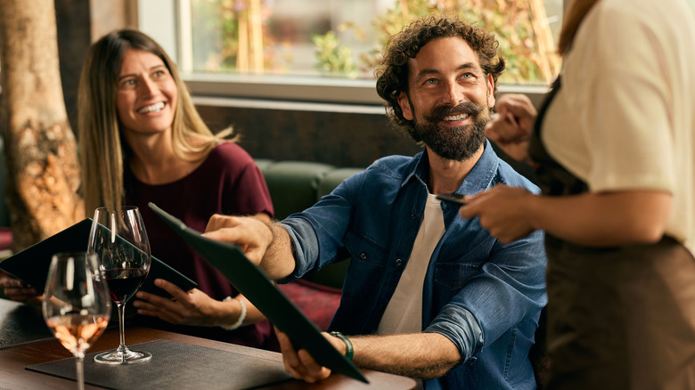 Couple ordering and looking at waiter
