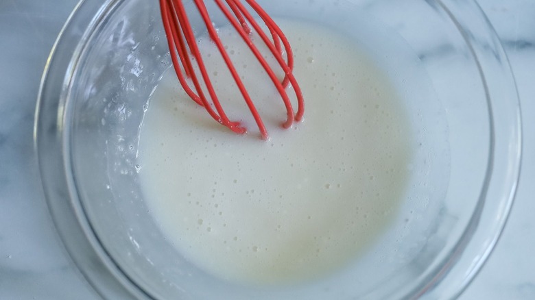 Vanilla glaze in bowl with whisk