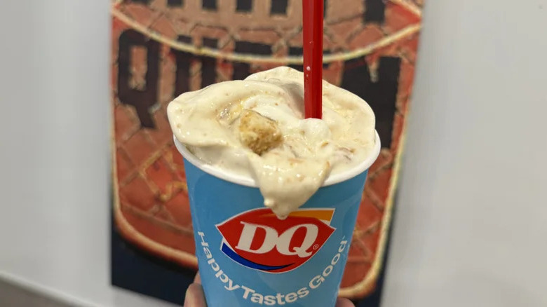 Dairy Queen caramel apple cheesecake Blizzard treat in front of a retro Dairy Queen logo