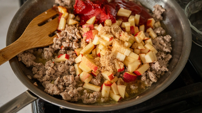 meat and apples in pan