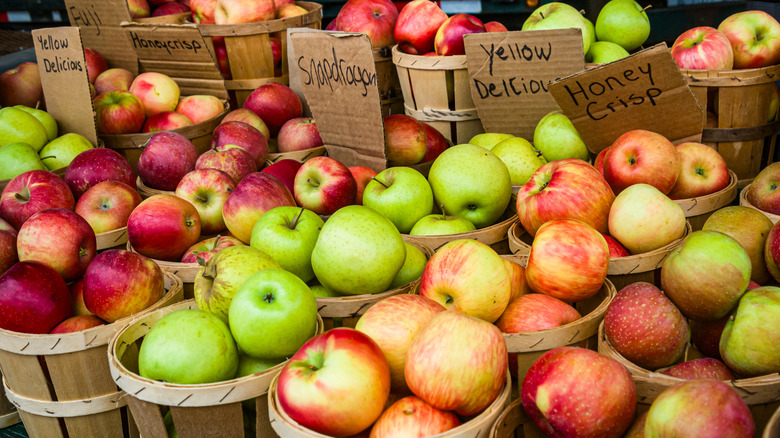 Different types of apples in baskets at a farmer's market
