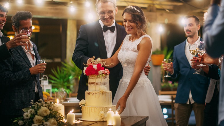 Groom and bride cutting a wedding cake 
