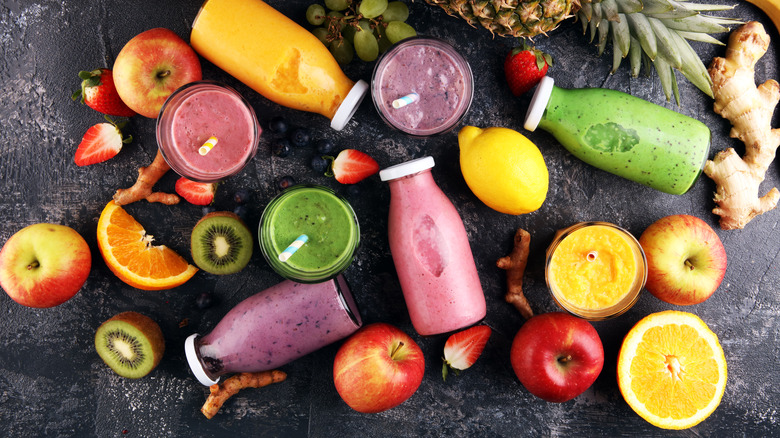 Top view of smoothies in bottles next to fruit