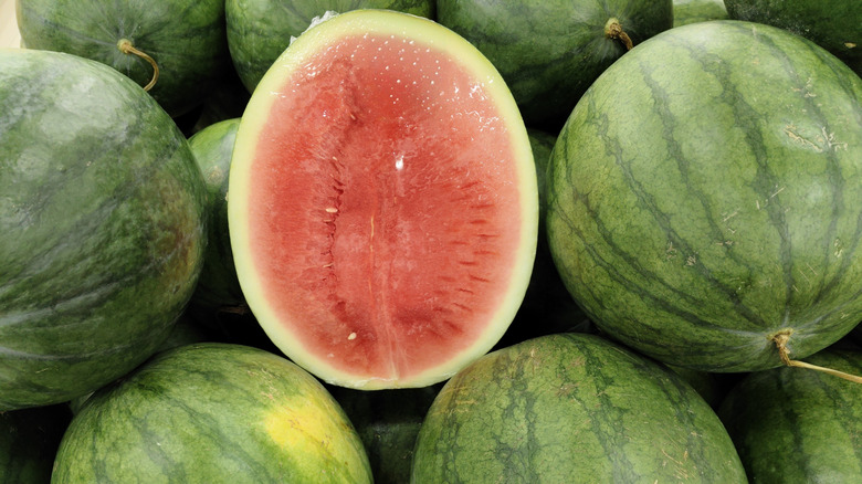 Seedless watermelon pile with the middle one sliced in half