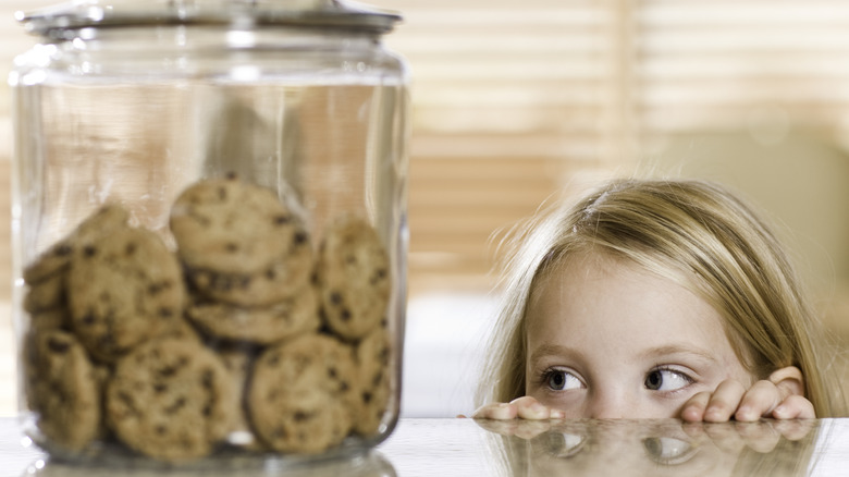 girl looking at a cookie jar