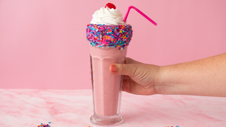 Barbie milkshake with straw and hand